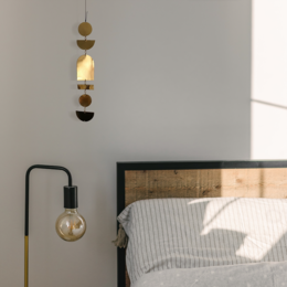 Brass statue with hanging light fixture, featuring a modern, minimalist design.