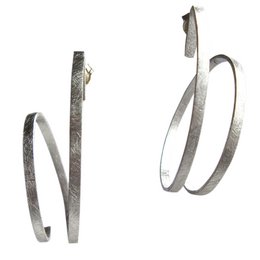 Twisted, statement-making earrings with a unique, modern design. Crafted from a metallic material, these earrings feature a curved, elongated shape that creates an eye-catching, sculptural look.