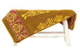 A small, rectangular alpaca blanket in a vibrant yellow color with a traditional Ecuadorian pattern featuring llama-like figures.