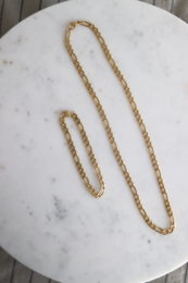 Gold twisted chain necklace with a charm pendant.