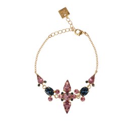 The Montana Bracelet is a charm bracelet featuring a gold-toned chain and a central floral design with purple, pink, and black gemstones. The bracelet has a delicate, feminine style.