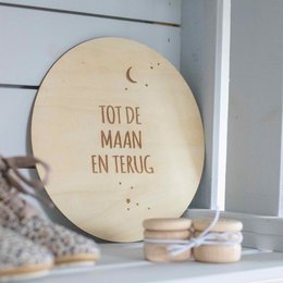 Wooden wall circle with text "Tot de maan en terug" (To the moon and back) in a rustic, handwritten style. The circle features a crescent moon and stars, creating a whimsical, celestial design suitable for a child's room or nursery.