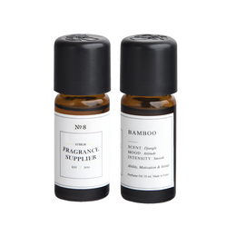 Two amber glass bottles with black caps labeled "No. 8 Bamboo" and "Bamboo" containing essential oil diffuser refills made from bamboo.