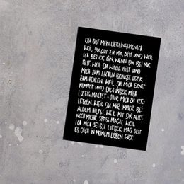 A postcard with a handwritten message expressing love and appreciation for a special person. The postcard has a simple, minimalist design with a black background and white text.