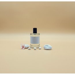 Elegant glass perfume bottle with floral accents and decorative stones, suggesting a high-quality, feminine fragrance.