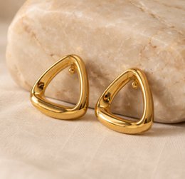  Stainless steel stud earrings with a triangular shape in a gold tone finish.