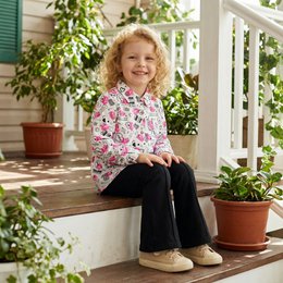 Long sleeve blouse for kids in a floral print pattern with a button-up front closure. Available in pink and yellow color variants.