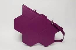 Hexagonal-shaped purple handbag with a structured geometric design and a detachable strap.