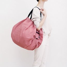 A large, foldable shopping bag in a peach (momo) color. The bag has a compact, collapsible design and is made of durable, high-quality materials.