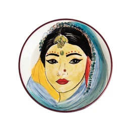 "Decorative ceramic dish featuring a colorful illustration of a woman's face with traditional Indian features and jewelry. The dish is 11 cm in diameter and is part of the 'Women of the World' collection."