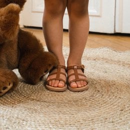 Cognac-colored leather sandals with straps for kids, available in sizes 25-29.