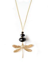 Long necklace with black Swarovski crystals and a dragonfly pendant in a gold tone. The necklace features a delicate chain and a statement dragonfly charm with a textured, hammered finish.