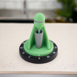 Green kitchen timer with a round base and a tall, cylindrical body.
