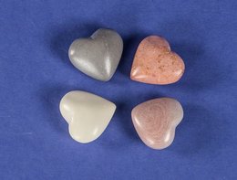 Four heart-shaped soapstone statues in natural colors including gray and pink.