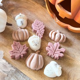 Scented fondants in an autumn collection, featuring a variety of fall-themed shapes and colors including pumpkins, leaves, and other seasonal motifs. The fondants come in different scents like balade en forêt, citrouille vanillée, figue & santal, and more.