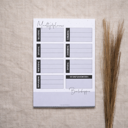 A5 weekly meal planner with minimalist design and lined sections for planning meals, grocery lists, and notes.
