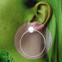 Statement earrings with a large circular design in a silver tone metal. The earrings feature a simple, modern style that would complement a variety of outfits.