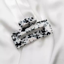 Black and white patterned hair clip with a classic claw design for securing hair.