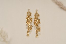Gold-toned statement earrings with a cascading leaf design.