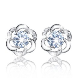 White flower stud earrings with sparkling cubic zirconia stones in a floral design. Elegant and feminine accessory suitable for formal or casual wear.