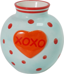  A round, tall ceramic vase with a polka dot pattern and an orange heart-shaped design that says "XOXO" in the center.