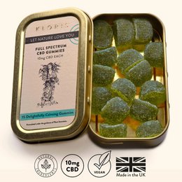 Full spectrum CBD gummies in a yellow tin container. The gummies appear to be golden in color and shaped like cubes or squares.