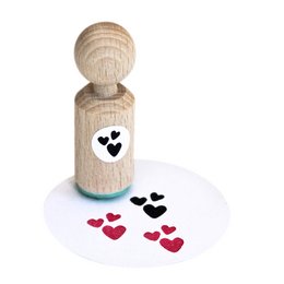 A wooden stamp with a heart design, used to create heart-shaped impressions on paper or other surfaces. The stamp has a round wooden handle and the heart design is printed on the stamp face.