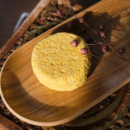 Solid shampoo bar made with natural ingredients like nelke, caffeine, and nettle. Available in cotton bag or without. Circular shape with earthy tones.