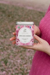 Organic herbal tea in a pink tin with floral design, featuring a variety of 120g and refill options.
