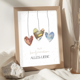  Colorful heart-shaped posters for money gifts, featuring the text "Alles Liebe" (All the Best). The posters are displayed in a wooden frame and appear to be made of paper or fabric.