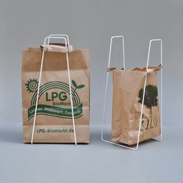 A rectangular paper shopping bag with a white handle and the text "LPG" printed on it in green. The bag appears to be made of brown kraft paper.