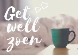 A green ceramic mug with the text "Get well soon" written on it, surrounded by hearts. The mug is placed on a soft, blurred background.
