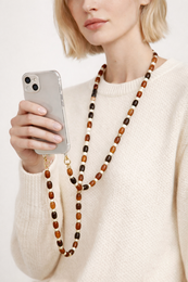 A long phone chain necklace made of oval-shaped beads in various shades of brown, orange, and white.