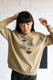 Oversized beige sweatshirt with a graphic design, suitable for casual wear. Made of soft, comfortable material.