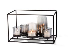 A modern, minimalist tea light holder with a black metal frame and various glass candle holders of different shapes and sizes.