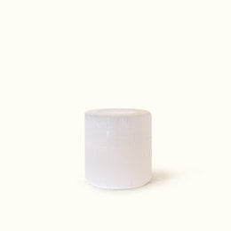 Round, white selenite tea-light candle with a soft, glowing light.