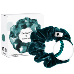 Velvet scrunchie in a rich, deep green color. Made of soft, plush velvet material. Features a small heart-shaped accent. Ideal for adding a touch of elegance and style to any hairstyle.