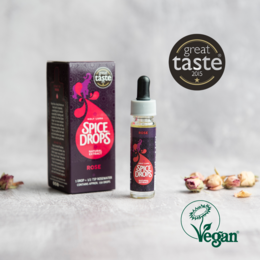Rose natural extract, vegan spice drops in a glass with fresh berries. Award-winning, natural flavors.