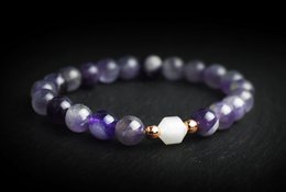 Elegant amethyst and quartz bracelet with a gold accent bead, suitable for casual or formal wear.