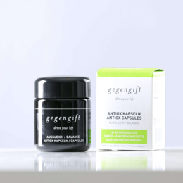 Antiox capsules are superfood supplements in a black bottle with a green and white label. The capsules appear to be green in color.