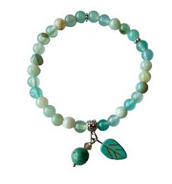  A delicate bracelet featuring a mix of chalcedony beads in shades of green, accented with leaf and stone charms. The bracelet has a natural, earthy aesthetic.