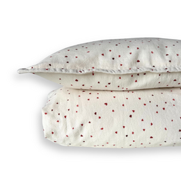  Soft, cozy duvet cover set featuring a delicate heart print pattern in shades of red on a light background. Available in junior and baby sizes.