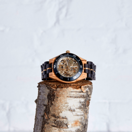 Handmade vegan wood mechanical watch with a skeleton dial, gold-tone accents, and a dark blue bezel.