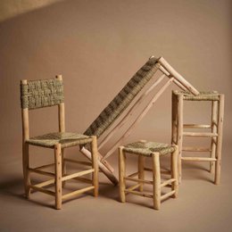  Low stool made of natural wood and woven straw, with a square shape and neutral tones.