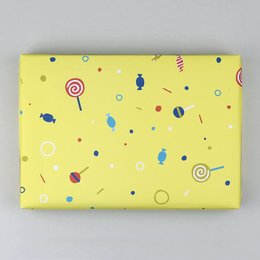 Wrapping paper with a colorful, playful pattern of lollipops, spirals, and other whimsical shapes on a bright yellow background. This wrapping paper would be suitable for a variety of occasions, especially for children's gifts.