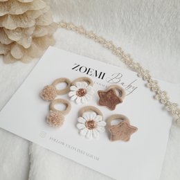  Warm winter hair ties for kids, featuring a variety of neutral-toned floral and textured accents.