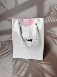  White paper shopping bag with the text "SHOPPER REGALO" printed on it.