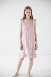 A loose-fitting, sleeveless nightgown in a soft, pale pink color. The dress has a ruffled neckline and a slightly flared, knee-length skirt. It appears to be made of a lightweight, breathable fabric suitable for sleepwear.
