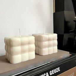 Soft, fluffy white candles with a square, textured design. Made of wax for home decor.