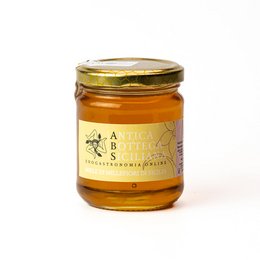 Sicilian millefiori honey in a glass jar with a golden lid. The honey has a rich, amber color and appears to be of high quality.